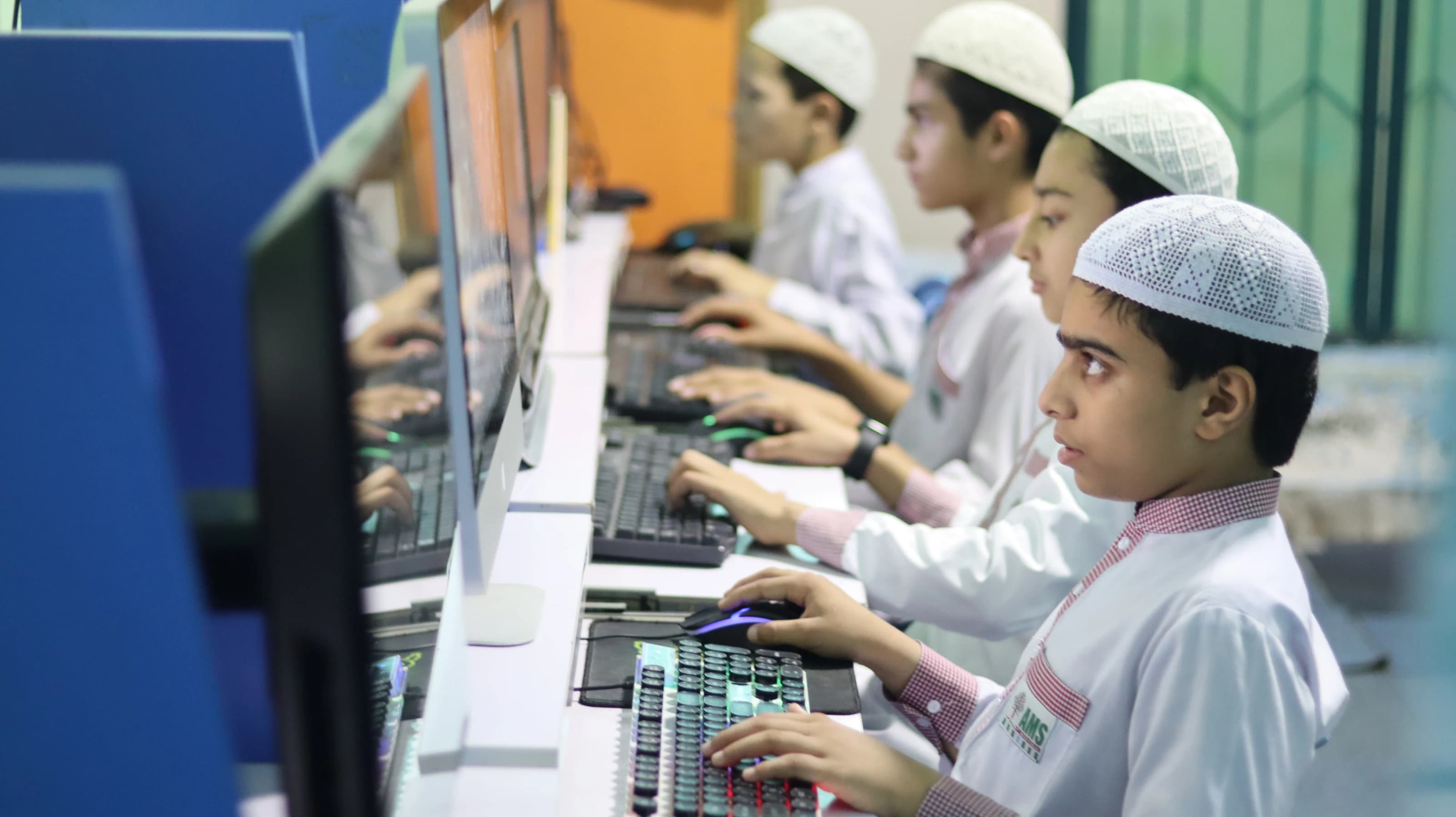 Students learning practical computer skills at AMS