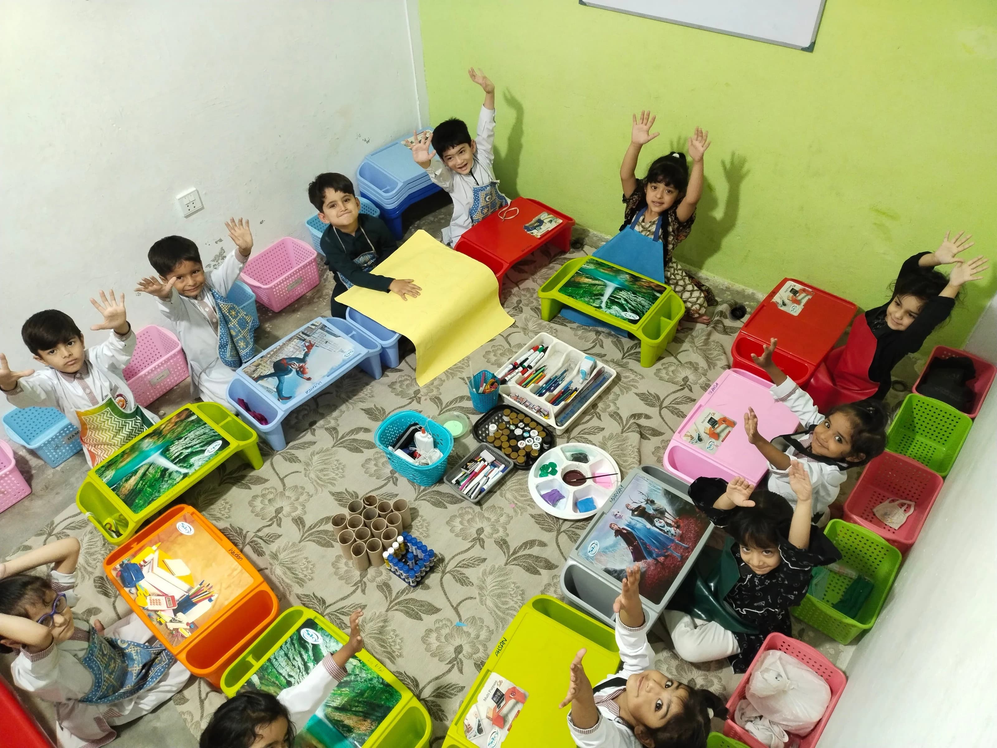 Children working together around classroom activity tables