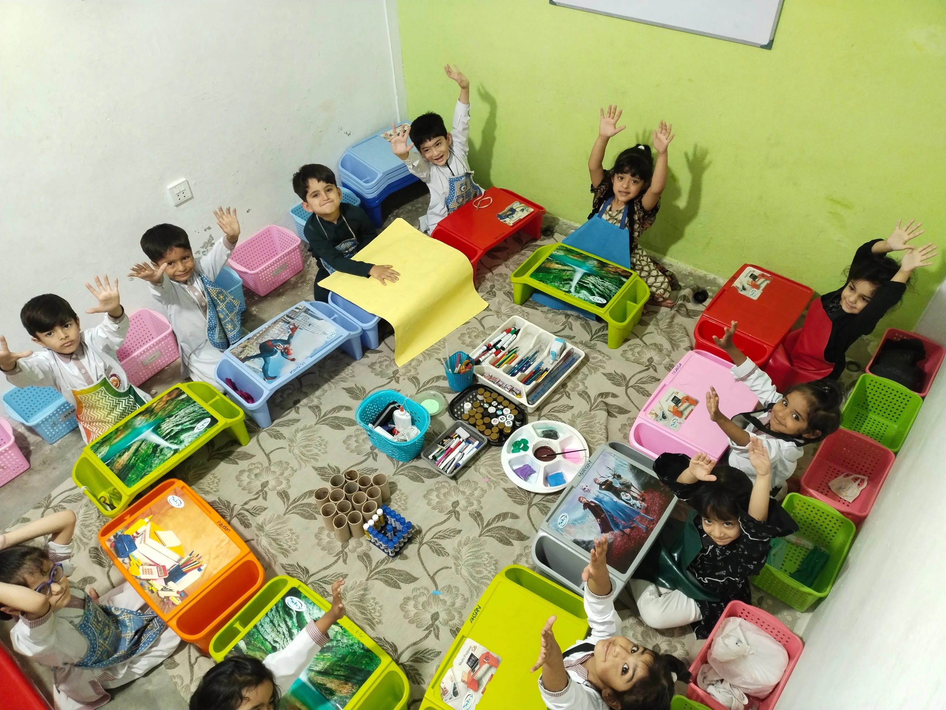 Children learning together around classroom activity tables