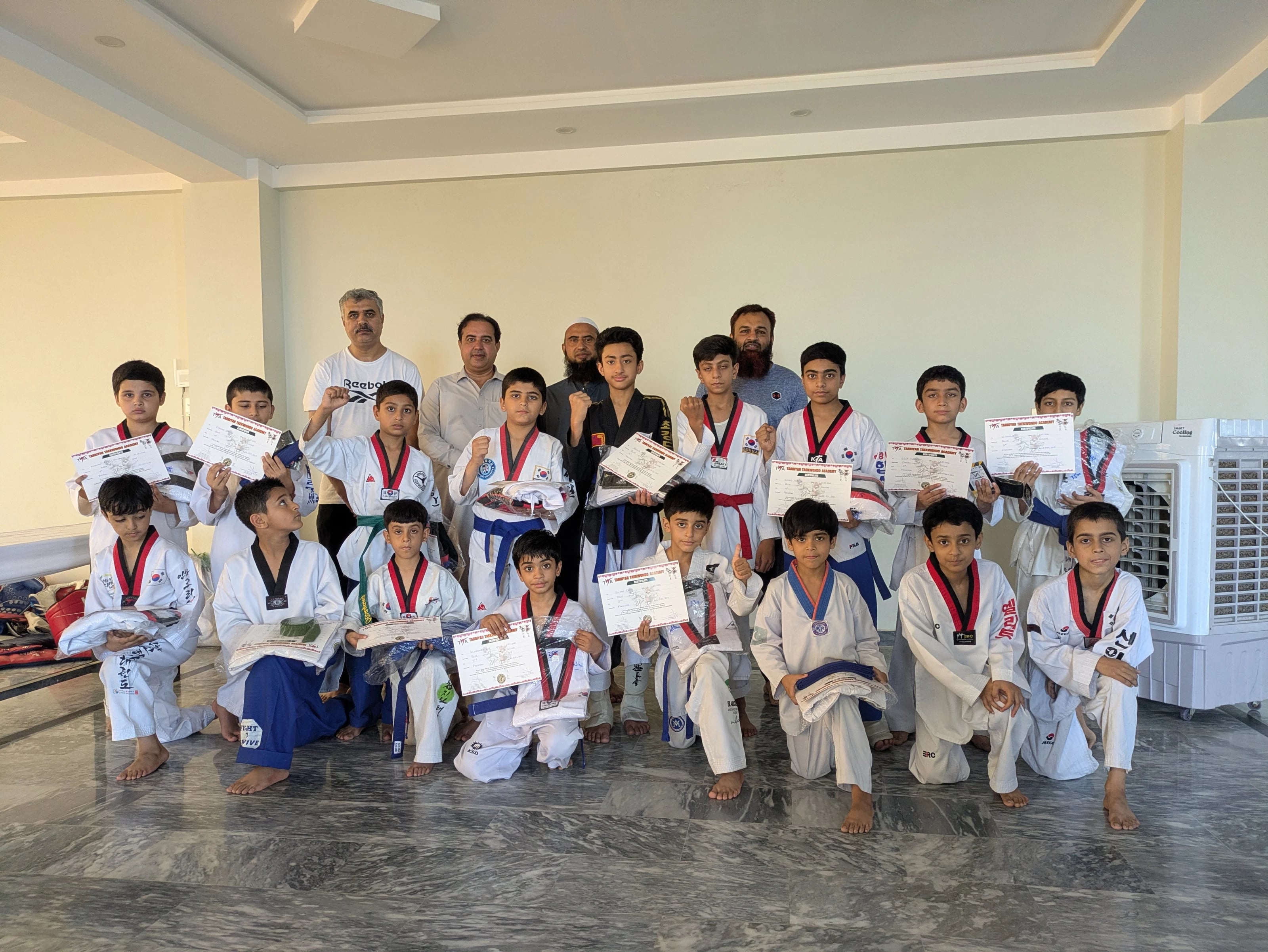 AMS students and teachers celebrating a taekwondo achievement